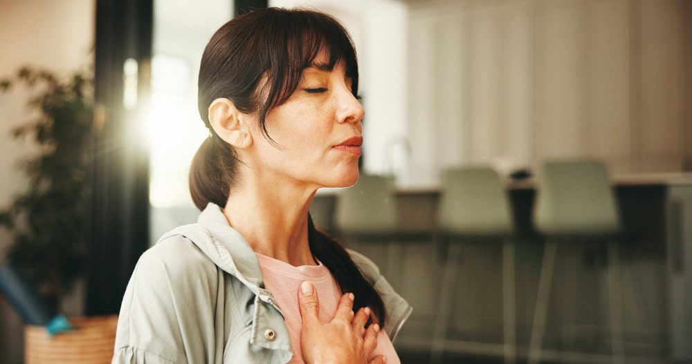 Woman taking a deep breath as she asks herself how can i practice mindfulness.